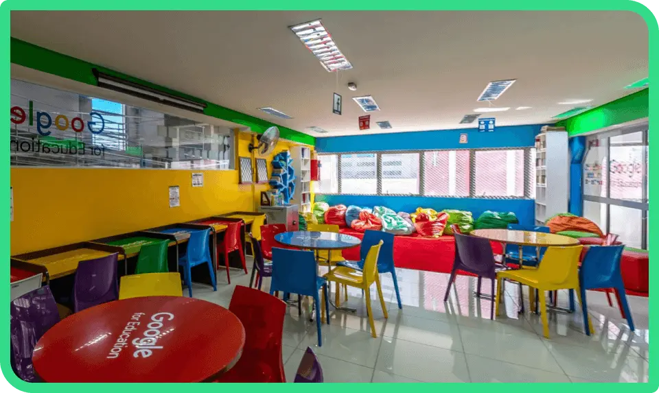 Refeitório da UniFECAF bem amplo e aberto com mesas e cadeiras de diferentes cores