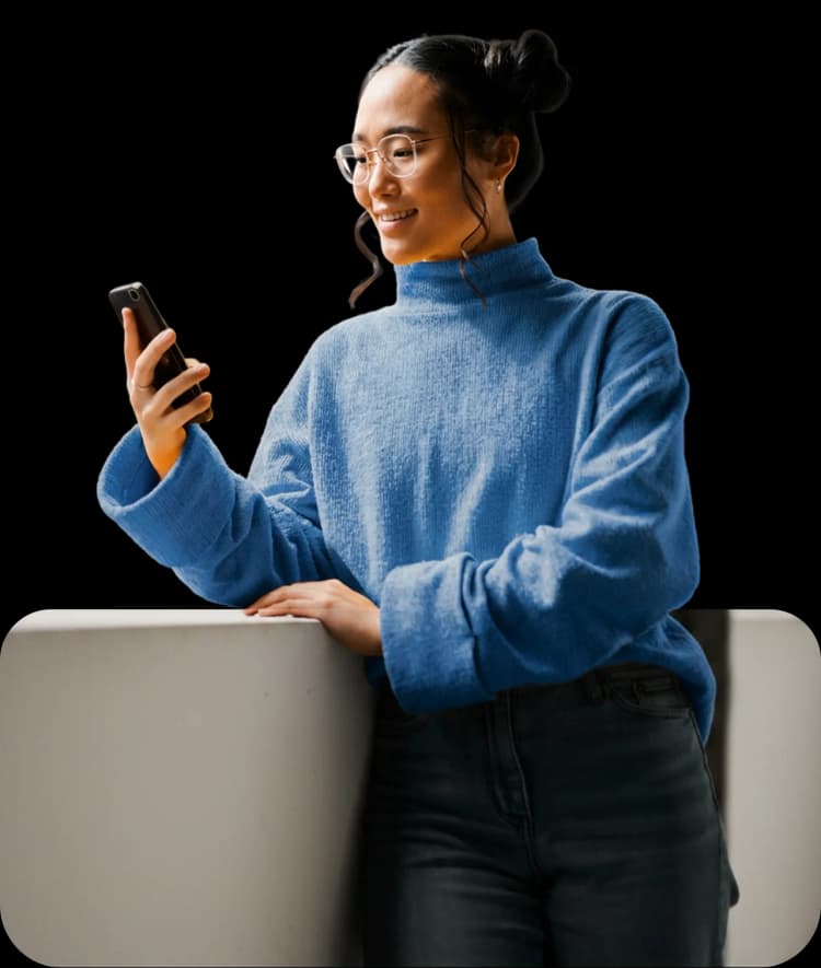 Aluna sorrindo enquanto usa o smartphone em uma videochamada